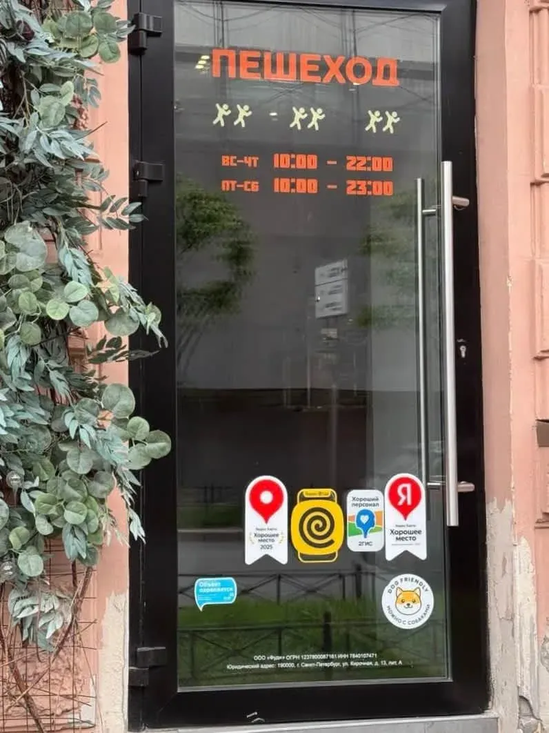 Дверь кафе «Пешеход» с расписанием работы и наклейками «Хорошее место» от Яндекса