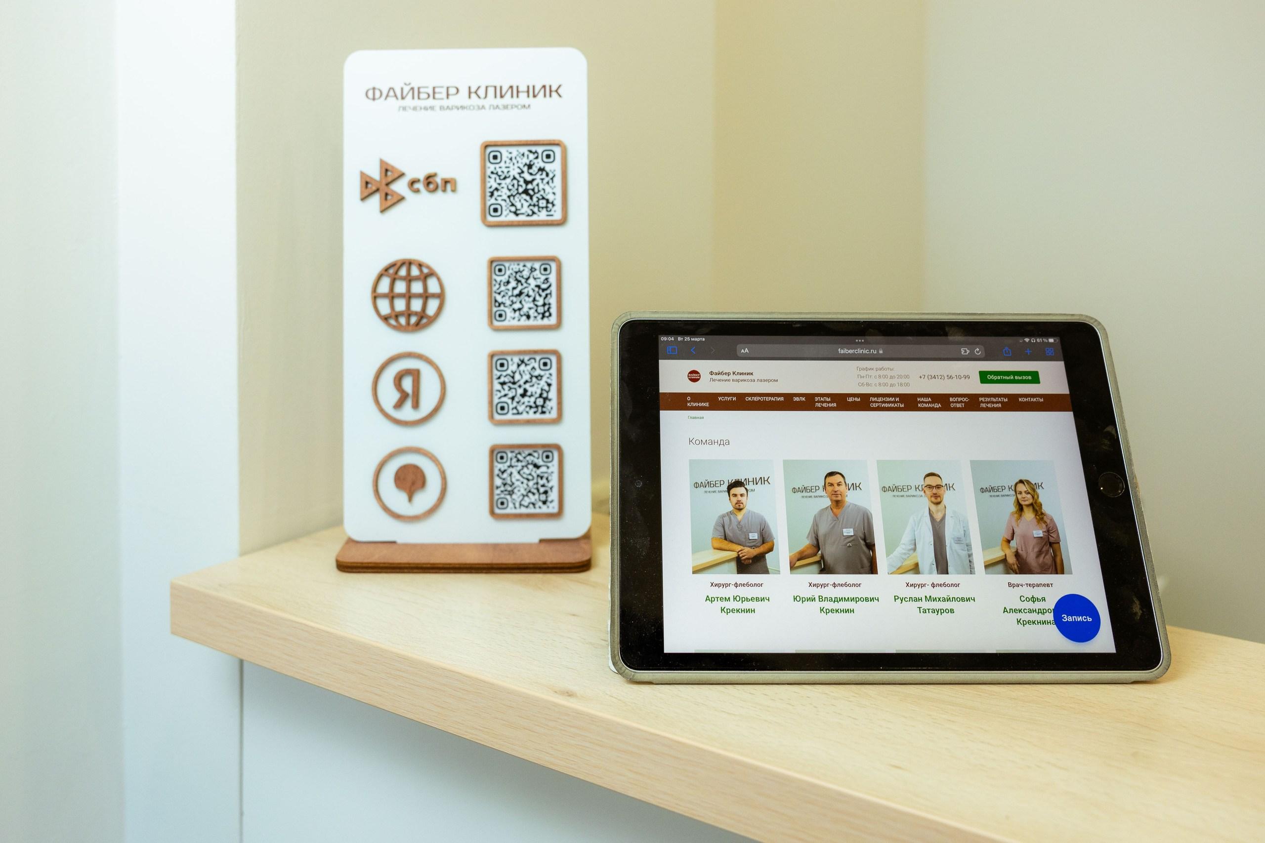 Планшет и визитка с qr-кодами на респешене Файбер клиник 