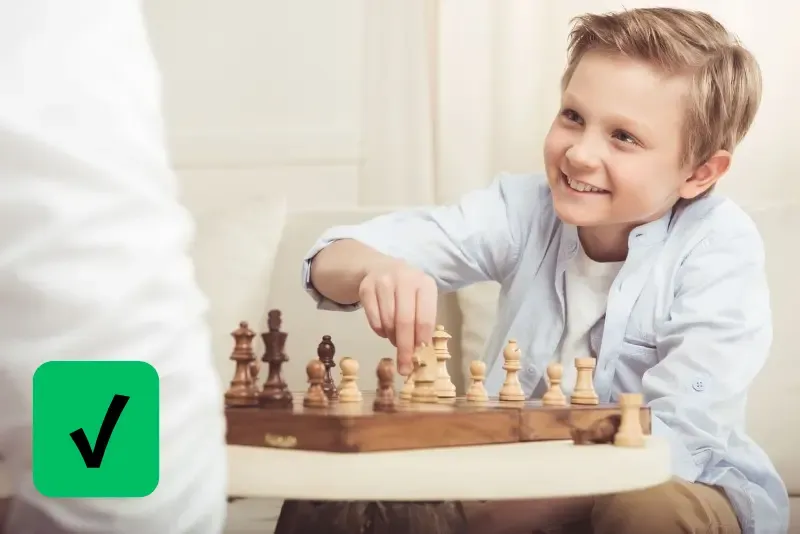 Счастливый мальчик играет в шахматы