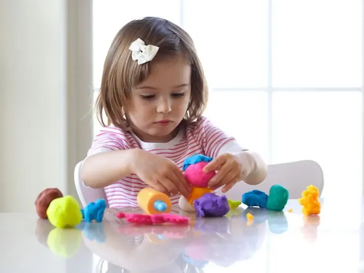 Девочка играет с игрушками, тактильные ощущения