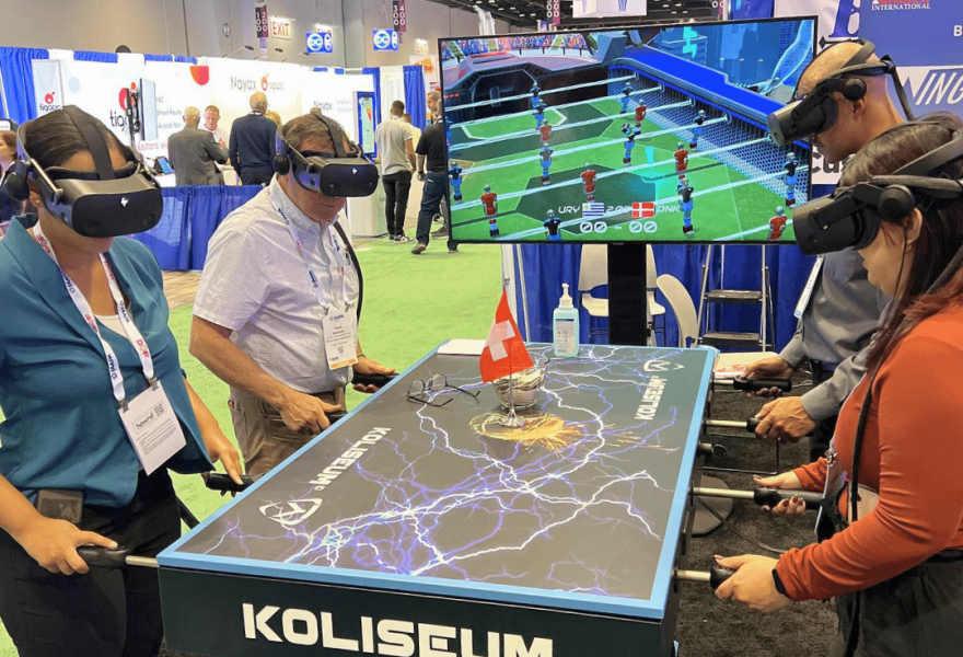 Посетители погружаются в виртуальный футбольный матч за интерактивным столом Koliseum во время выставки event expo