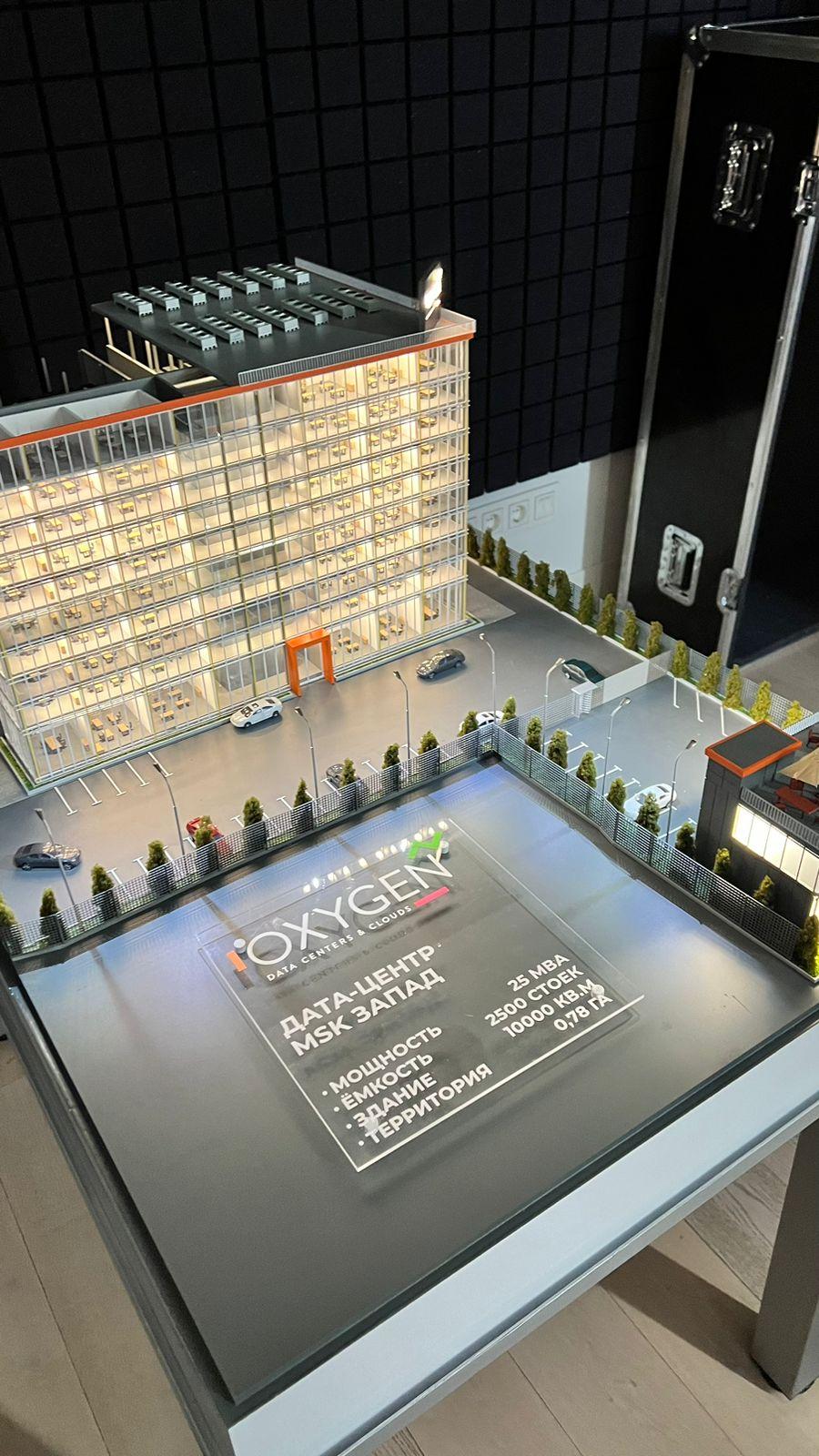 3D-масштабный макет современного дата-центра: многоэтажное здание с прозрачными фасадами, демонстрирующее внутреннюю планировку с рабочими местами. Включены детализированные элементы территории — парковка на 2500 мест, зелёные насаждения, зоны отдыха с мебелью под навесами. Указаны ключевые параметры: мощность 25 МВА, площадь здания 10 000 кв. м, площадь территории 0,78 га. Реалистичная модель для презентации архитектурного и инфраструктурного решения дата-центра.