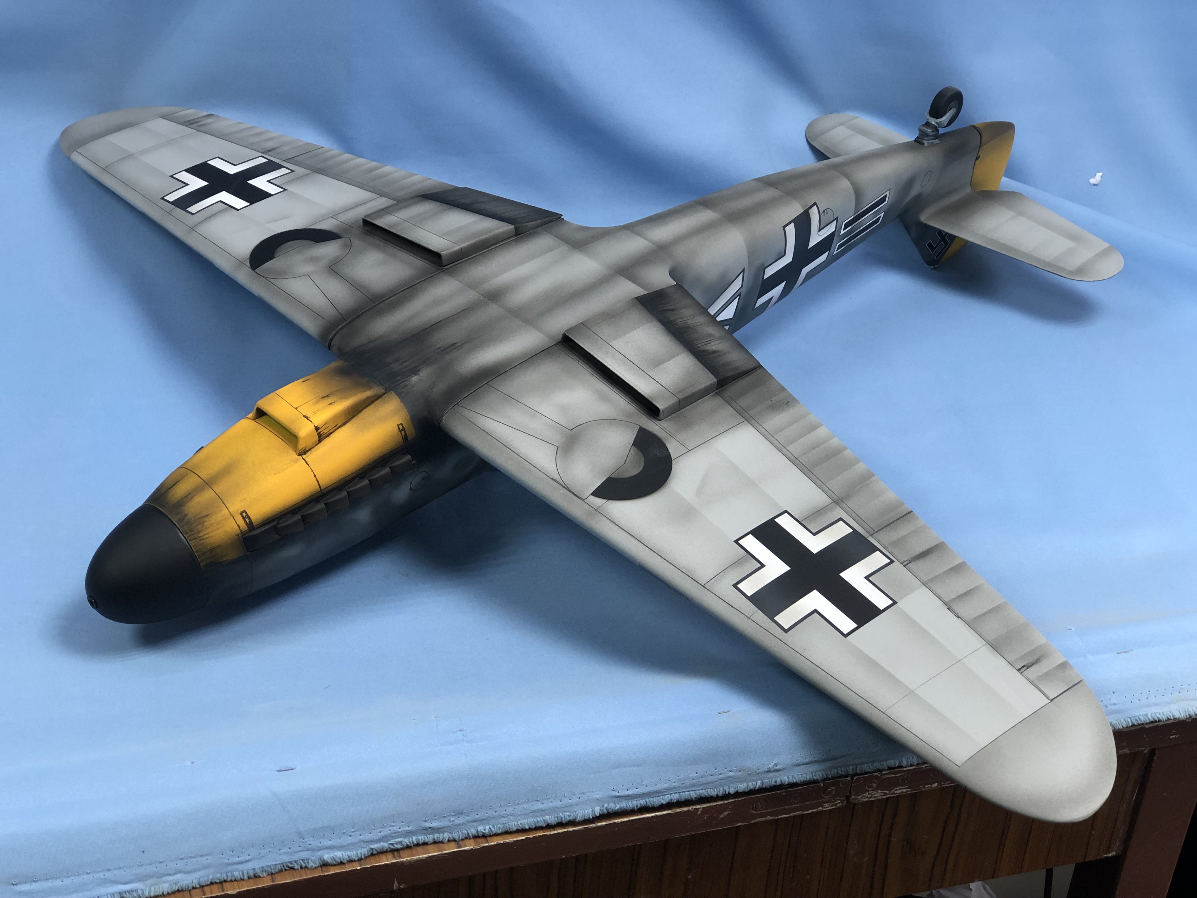  Фотография демонстрирует модель самолета Messer-Schmitt BF-109, изготовленную на заказ для музея. Модель выполнена с высокой точностью и детализацией, что позволяет оценить историческую значимость и качество работы мастеров. Она предназначена для демонстрации в музее