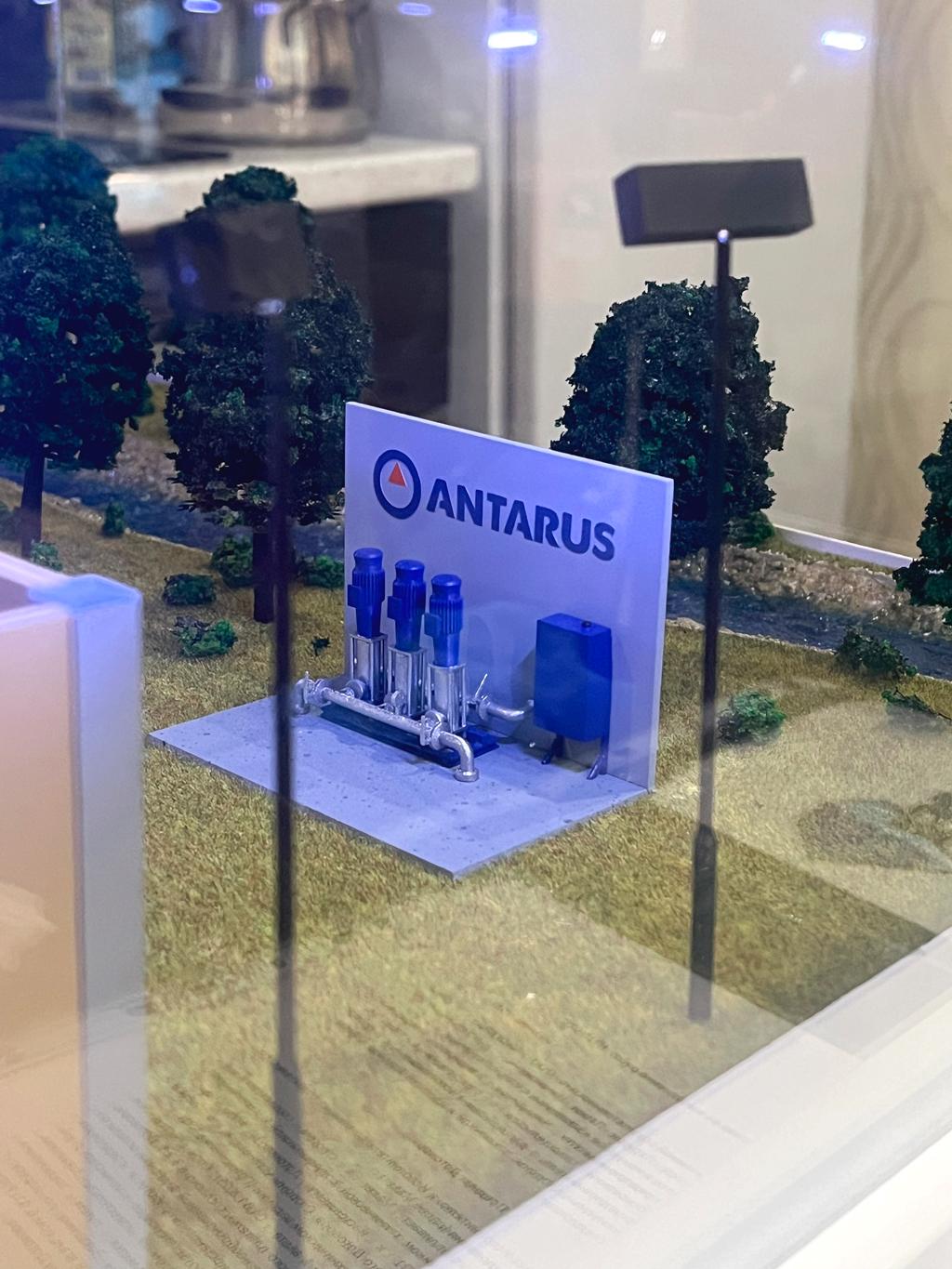 Модель насосной станции, выполненный в уменьшенном масштабе. Такое сооружение называется комплектная повышающая насосная станция. Повышающие насосные станции необходимы для обеспечения: • Повышения давления воды в системах водоснабжения (например, в городских кварталах, жилых домах, промышленных объектах). • Перекачки воды/жидкости на большие расстояния и/или в высокие здания, где обычного давления недостаточно. • Стабильного и надёжного водоснабжения при переменных нагрузках.  Для чего это нужно: • Для обеспечения бытовых, промышленных дозировок воды. • Для систем пожаротушения, орошения, канализации и других инженерных сетей. • Для поддержания необходимого давления в трубопроводах независимо от расхода воды и высоты зданий.