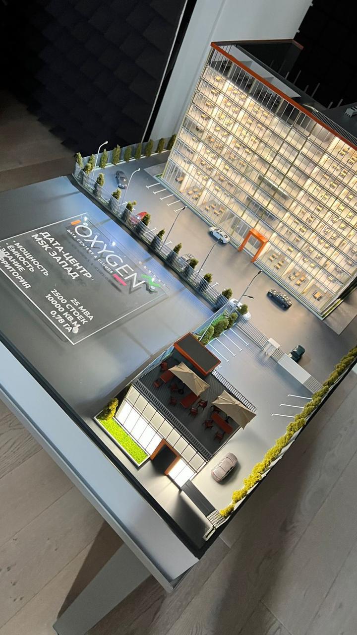 3D-масштабный макет современного дата-центра: многоэтажное здание с прозрачными фасадами, демонстрирующее внутреннюю планировку с рабочими местами. Включены детализированные элементы территории — парковка на 2500 мест, зелёные насаждения, зоны отдыха с мебелью под навесами. Указаны ключевые параметры: мощность 25 МВА, площадь здания 10 000 кв. м, площадь территории 0,78 га. Реалистичная модель для презентации архитектурного и инфраструктурного решения дата-центра.