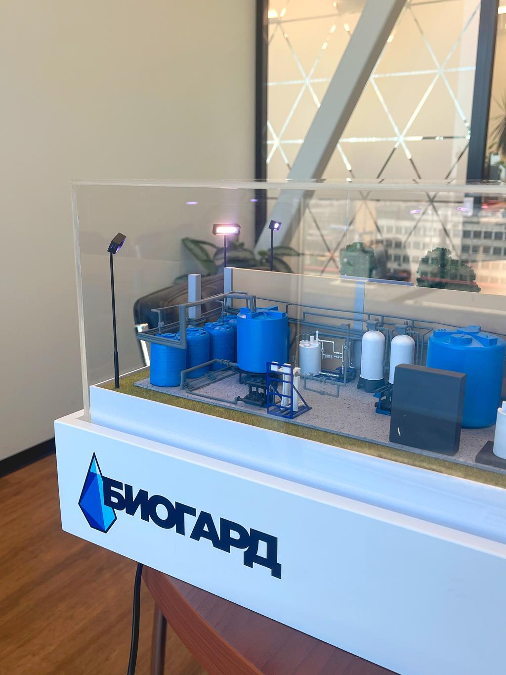 Макет установки водоподготовки / станции очистки сточных вод модульного типа, изготовленный на заказ в студии макетов для выставки. Такие технологические комплексы предназначены для очистки промышленных, ливневых или хозяйственно-бытовых сточных вод, либо для предварительной подготовки воды перед использованием в технологических циклах предприятий. Они позволяют:  • Очищать воду от механических, химических, биологических загрязнений. • Снижать концентрацию вредных веществ до нормативных показателей. • Обеспечивать повторное использование воды (замкнутый цикл). • Защищать окружающую среду от загрязнения.  Для чего нужен такой макет:   Макет используется для презентаций, обучения персонала, согласования проектов с заказчиками, демонстрации принципов работы и компоновки оборудования на выставках или в офисах предприятий.