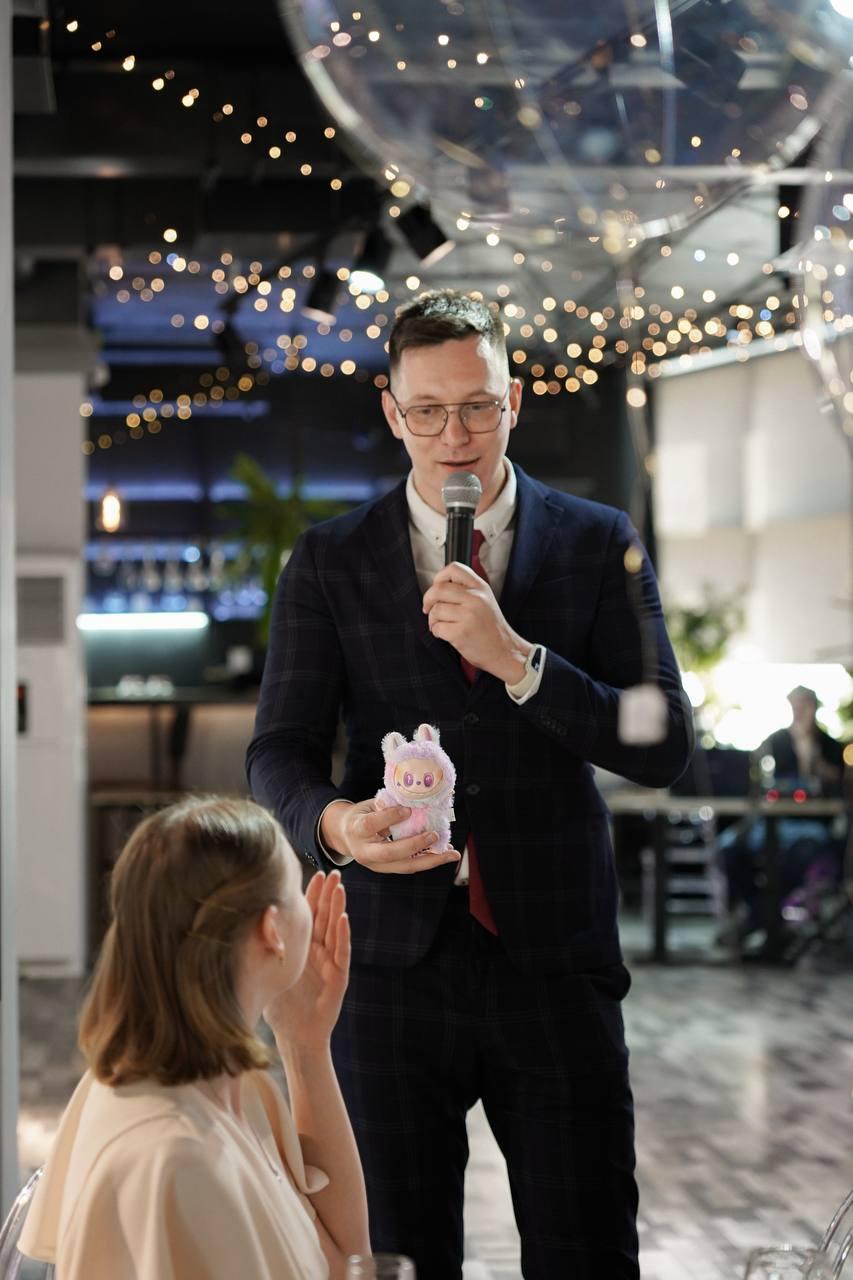 Молодожёны и гости на банкете, ведущий объявляет ключевой момент программы