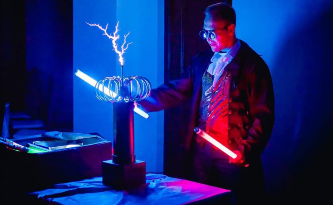 Ведущий показывает эксперимент на научном шоу, гости участвуют