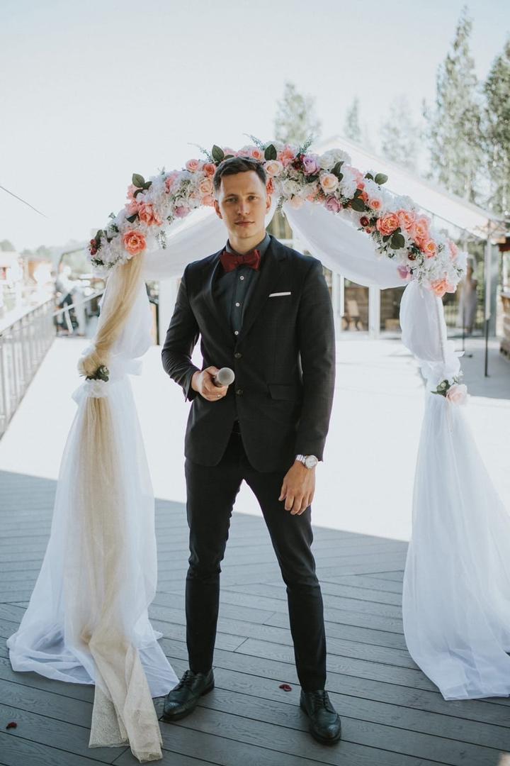 Ведущий ведёт свадебный вечер в ресторане, гости улыбаются и аплодируют