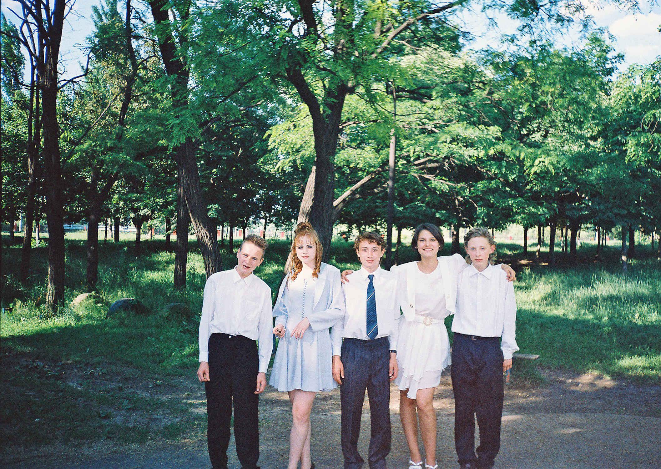 1997 июнь, выпускной, на школьном дворе. Можно увидеть лавочку, шины для прыжков и по ул. Артёма остановку и красные кирпичные опоры моста на набережной ставка