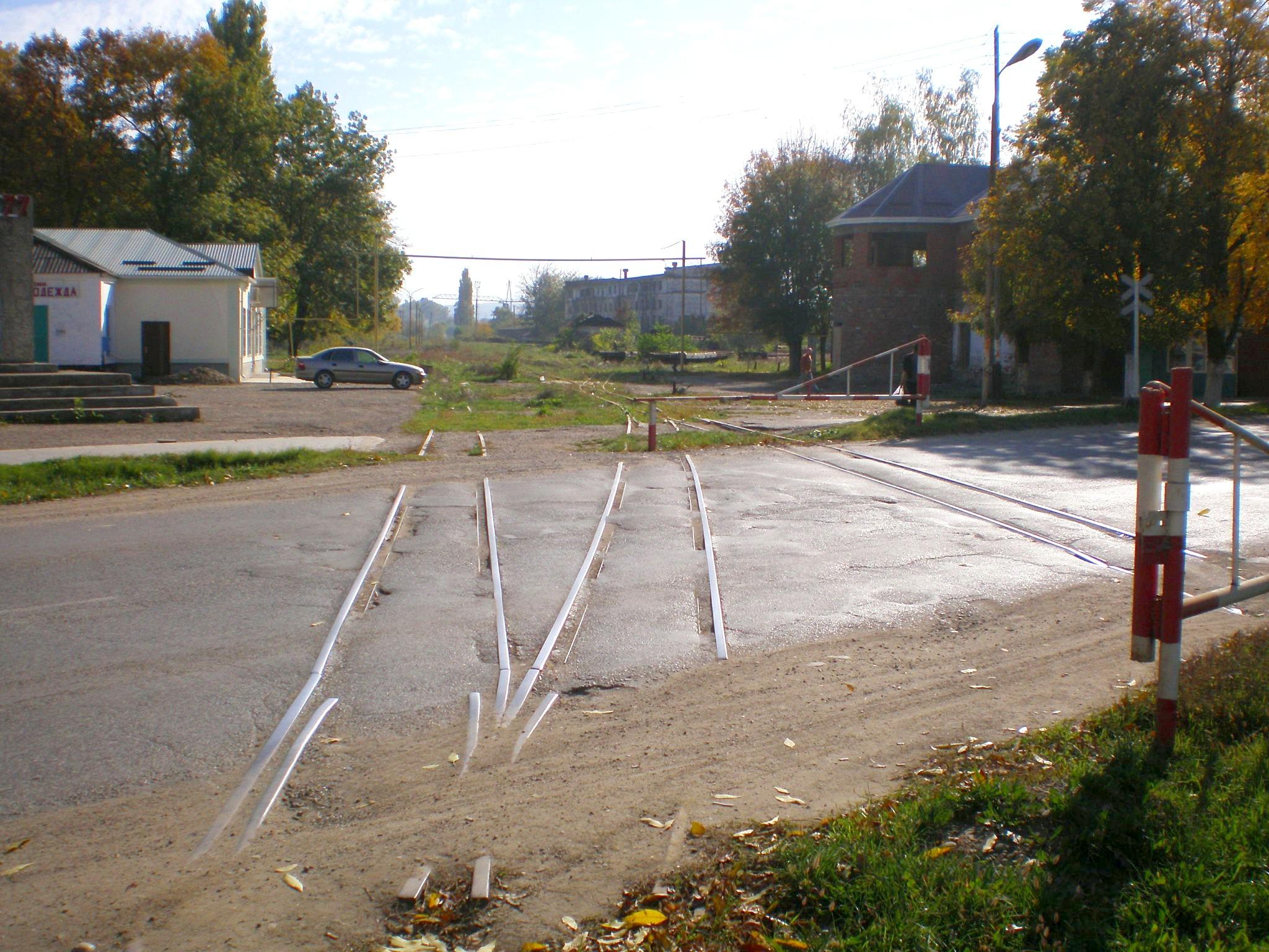 2007 Апшеронск, ул. Коммунистическая, пересечение узкоколейки с автодорогой, слева где автомобиль - вокзал узкоколейки