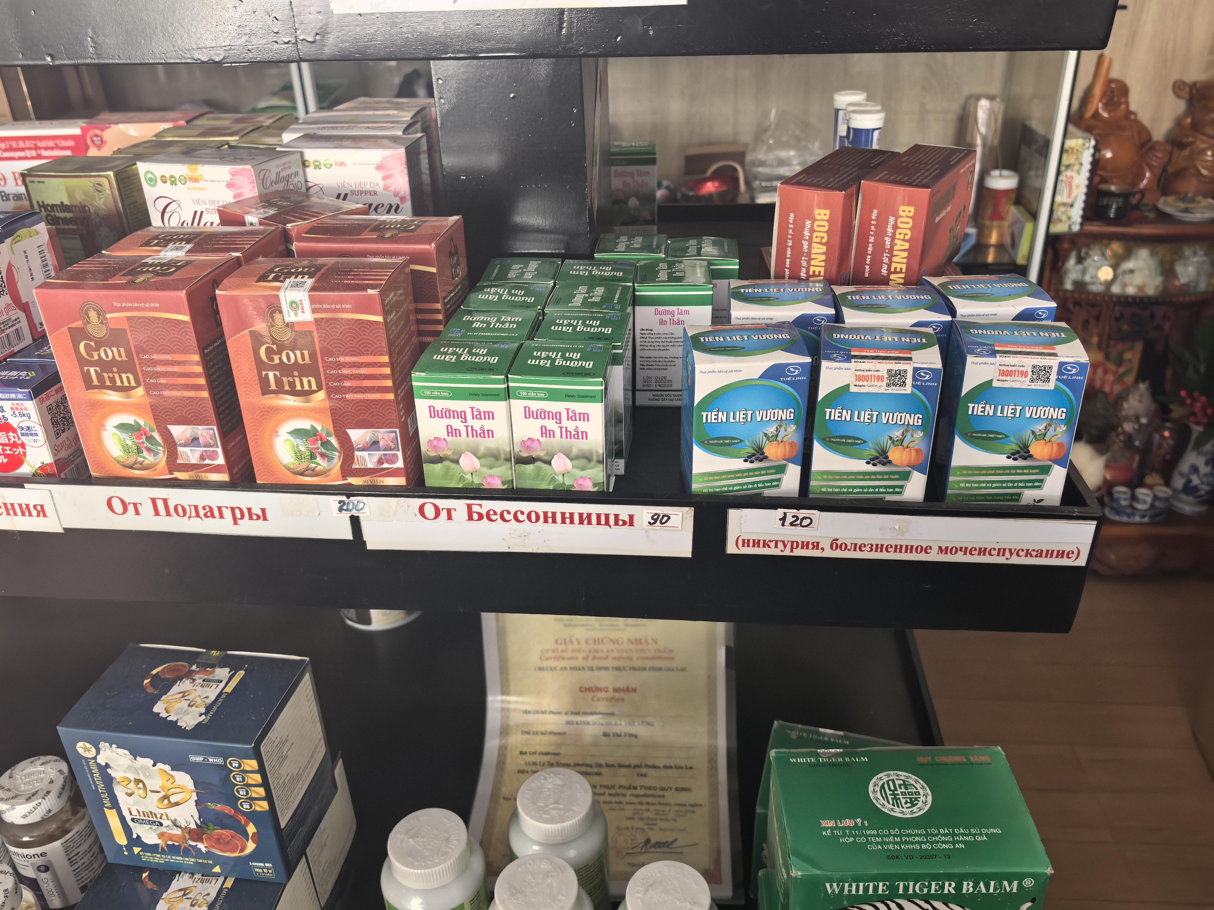 Полки вьетнамской аптеки с препаратами, промаркированными русскими названиями болезней:  "Бессонница", "Подагра".