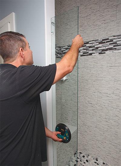 Квалифицированный монтаж — наши специалисты устанавливают конструкции по немецкой технологии, обеспечивая долговечность и безопасность Мастер устанавливает стеклянную перегородку в ванной комнате — используем немецкую технологию для надежного и герметичного соединения