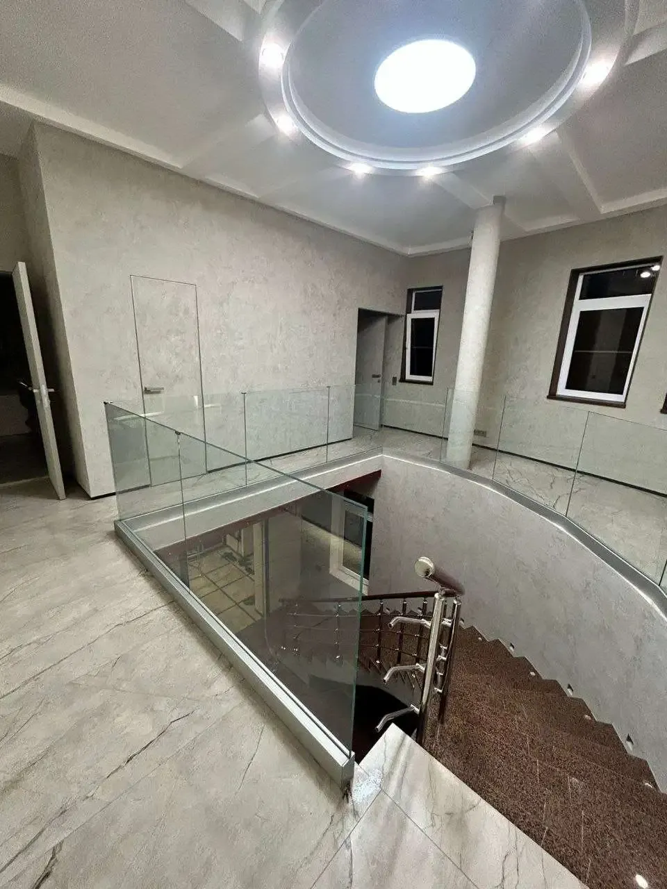 Стеклянное ограждение лестницы с фацетом и подсветкой в загородном доме Сочи