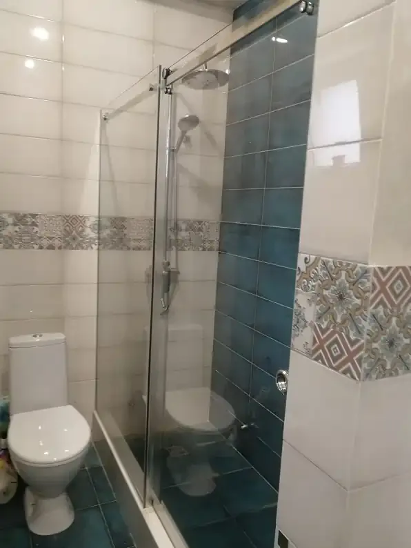 Раздвижная перегородка в ванной комнате с плиткой и унитазом — функциональное разделение пространства, подходит для любых стилей интерьера