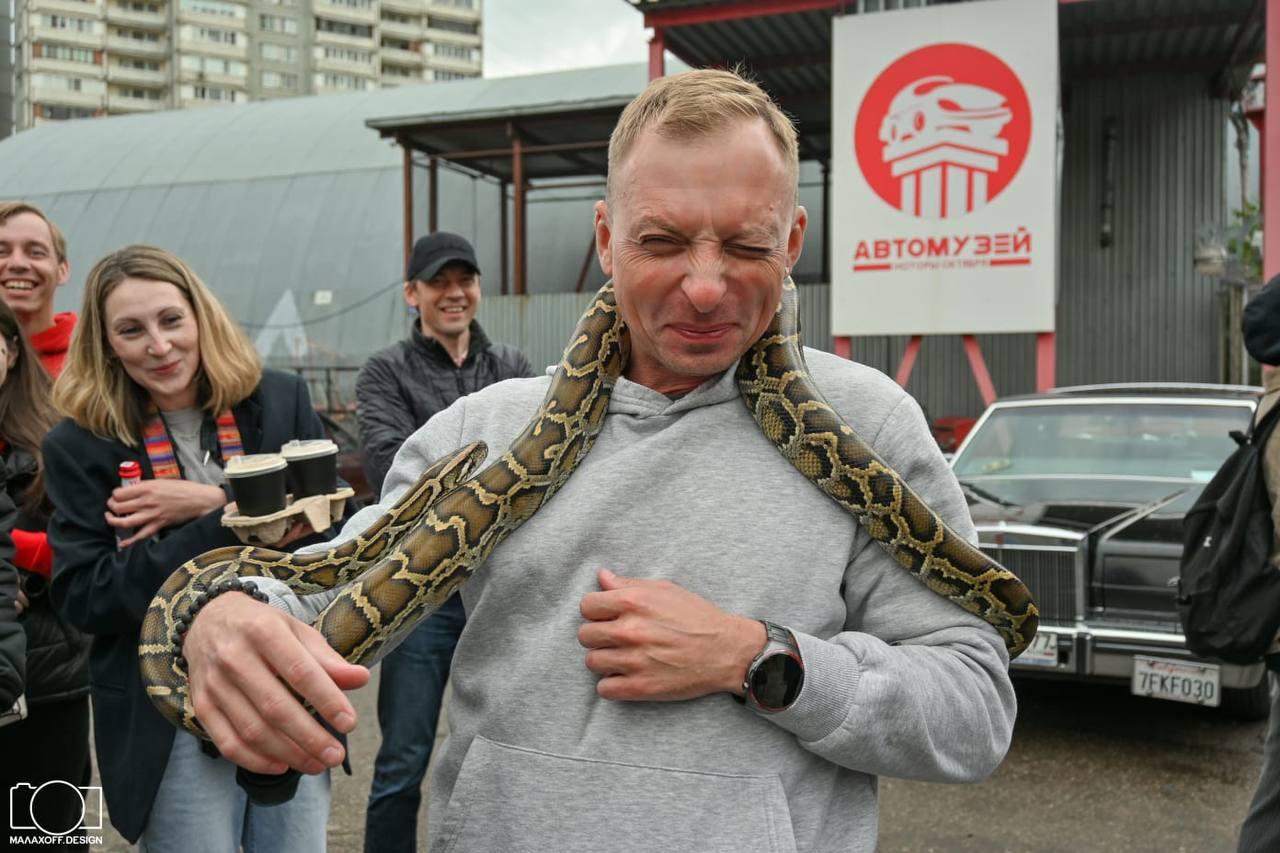 Мужчина с питоном на шее во время шоу с животными AMStudio в Москве