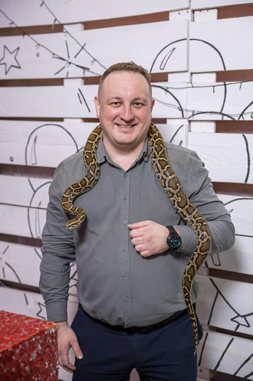 Гость держит питона на плечах на шоу Треш-коробка от AMStudio