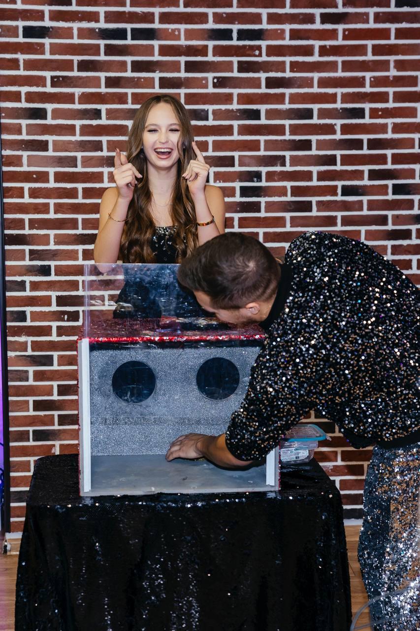 Шоу с животными AMStudio в Москве — ведущий готовит сюрприз в коробке, а гостья смеётся и ожидает испытание программы Треш-коробка