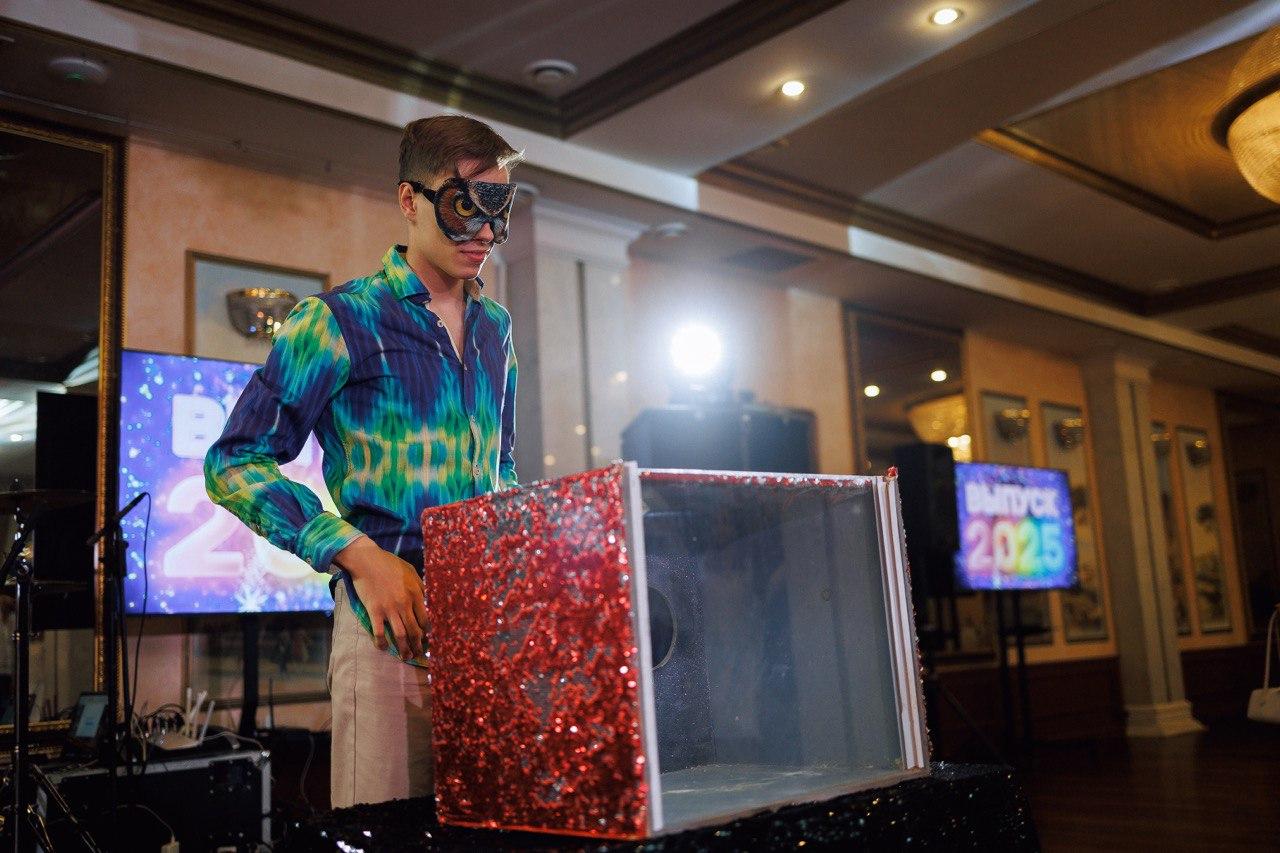 Шоу с животными AMStudio в Москве — участник в повязке на глазах стоит перед красочной коробкой, готовясь к испытанию программы Треш-коробка