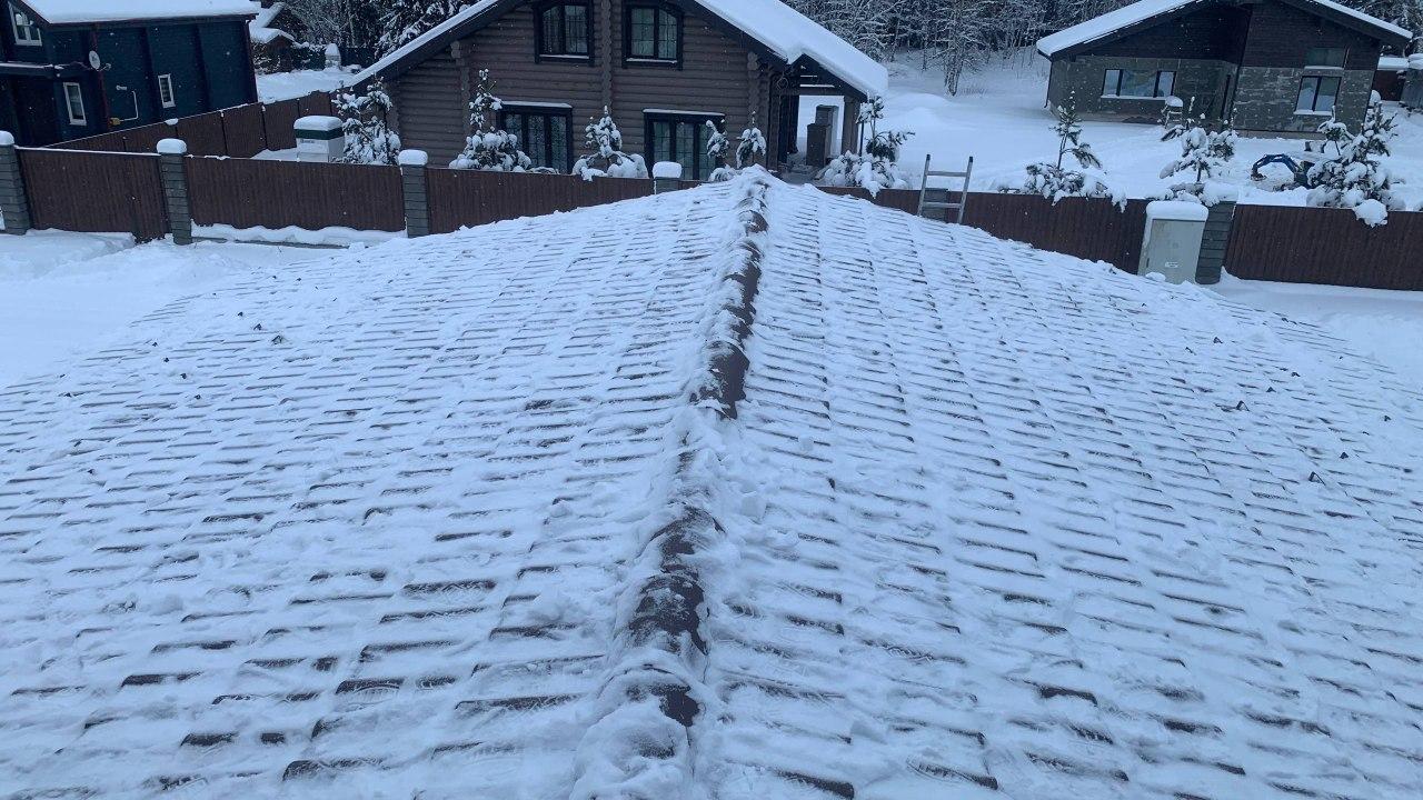 Очистка кровли дома от снежного покрова.