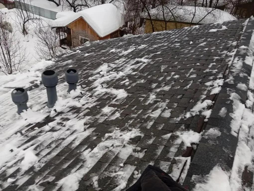 Очистка кровли дома от снежного покрова.