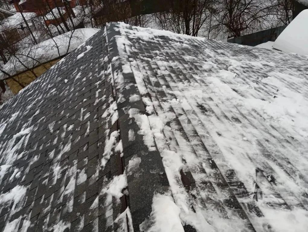 Очистка кровли дома от снежного покрова.