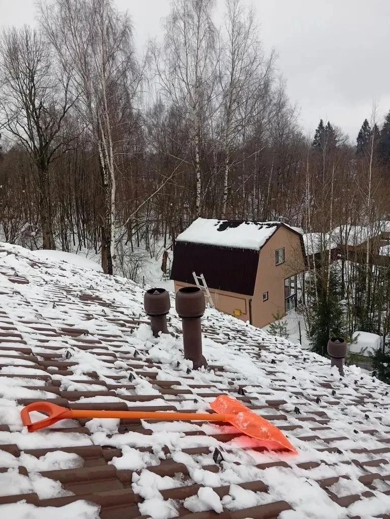 Очистка кровли дома от снежного покрова.