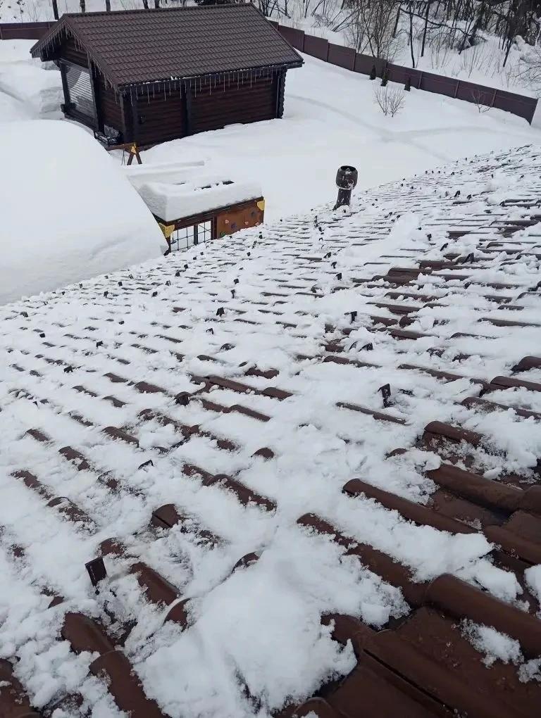 Очистка кровли дома от снежного покрова.