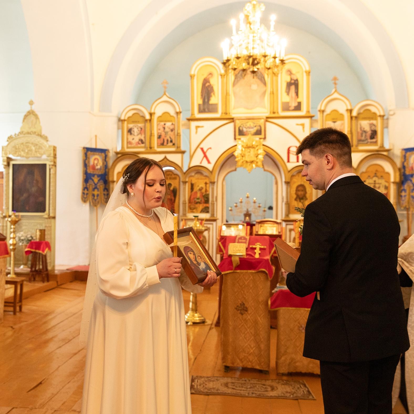 Венчание, невеста с иконой в руках задувает свечу